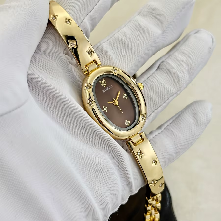 Montre ovale dorée tendance pour femme avec détail gravé en forme d'étoile : un accessoire intempore