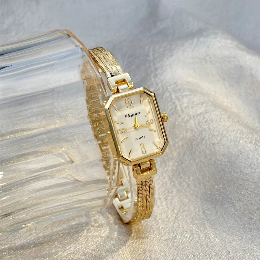 Montre-bracelet rectangulaire dorée pour femme avec chaînes à pampilles